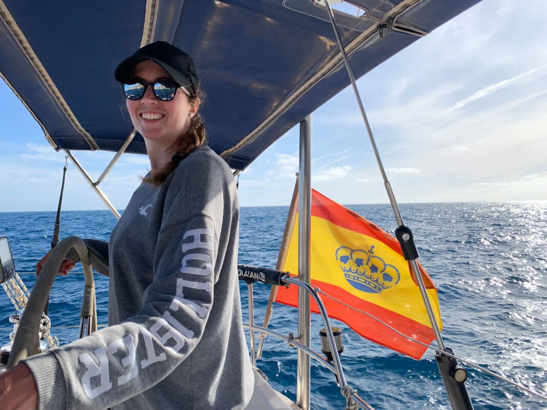 Elena al timón del velero Ciencia con la bandera de España