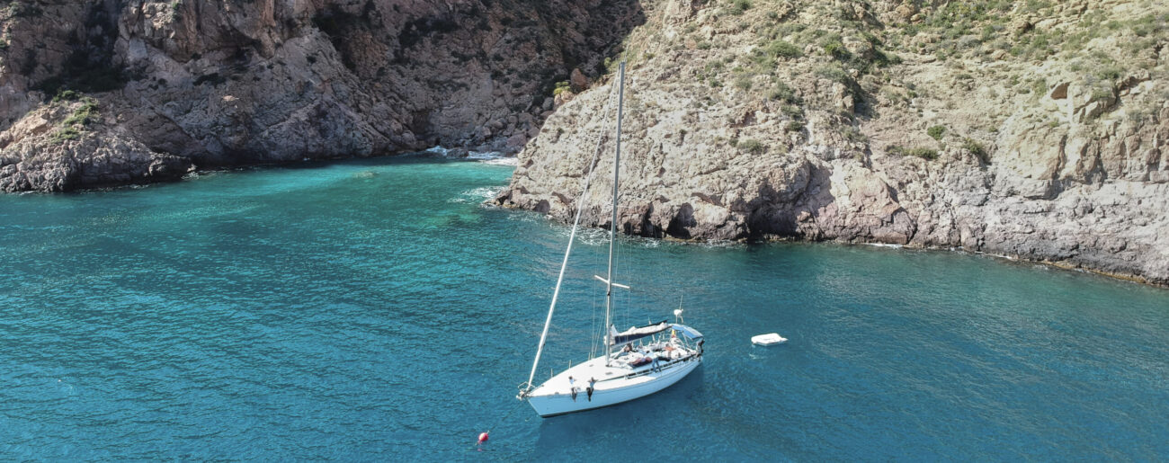 Velero fondeado en una cala de aguas turquesas